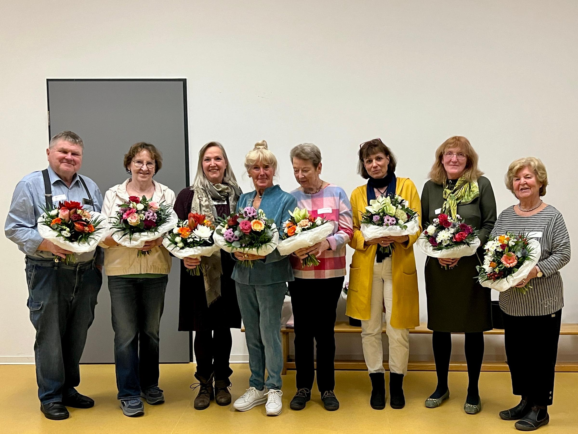 Acht Dozierende halten nach ihrer Ehrung beim Dozierendenfest Blumensträuße in ihren Händen.