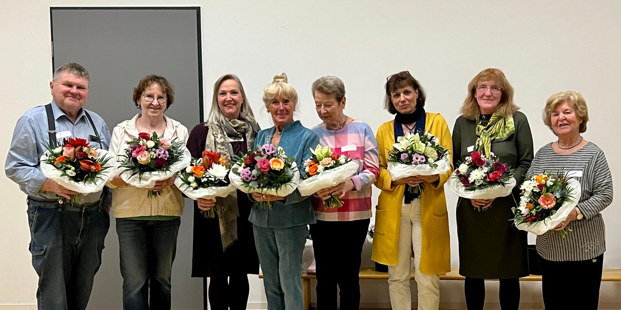 Acht Dozierende halten nach ihrer Ehrung beim Dozierendenfest Blumensträuße in ihren Händen.